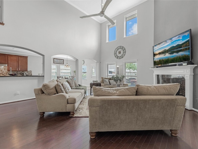 3310 Compass Ct, Conroe, TX 77301 - living room with ceiling fan, arched walkways, high vaulted ceiling, dark wood finished floors, and a high end fireplace