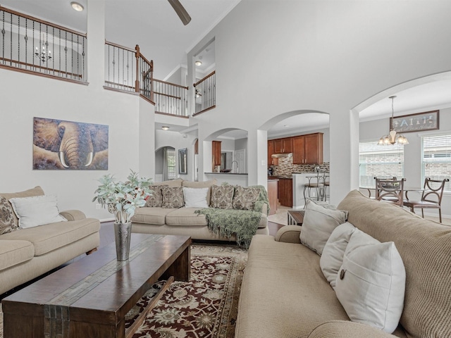 3310 Compass Ct, Conroe, TX 77301 - living area featuring a chandelier, ceiling fan, a high ceiling, and arched walkways