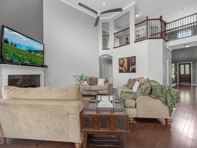 3310 Compass Ct, Conroe, TX 77301 - living room with dark wood-type flooring, crown molding, a ceiling fan, a high ceiling, and a premium fireplace