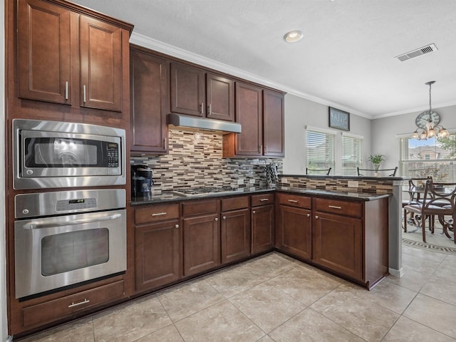 3310 Compass Ct, Conroe, TX 77301 - kitchen with stainless steel appliances, ornamental molding, a peninsula, decorative backsplash, and under cabinet range hood