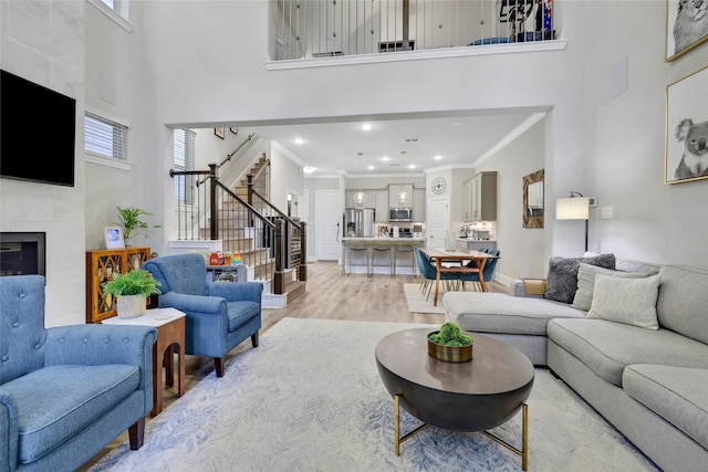 1002 Shepherd Oaks Dr, Houston, TX 77018 - living area featuring a high ceiling, stairs, crown molding, light wood-type flooring, and healthy amount of natural light