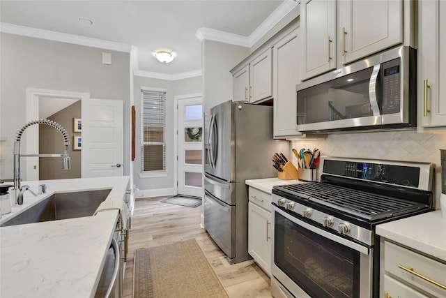 1002 Shepherd Oaks Dr, Houston, TX 77018 - kitchen featuring appliances with stainless steel finishes, decorative backsplash, ornamental molding, light stone counters, and light wood finished floors