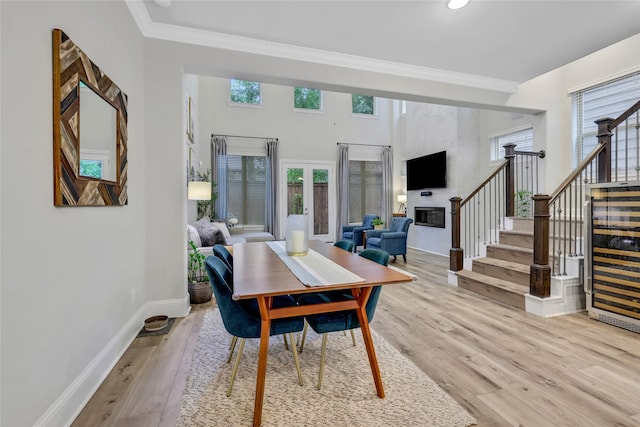 1002 Shepherd Oaks Dr, Houston, TX 77018 - dining space featuring ornamental molding, stairs, light wood finished floors, a glass covered fireplace, and recessed lighting