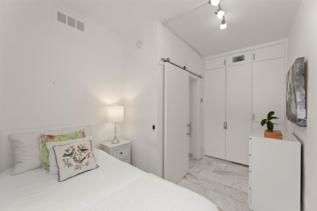5555 Del Monte Dr Unit T24, Houston, TX 77056 - bedroom featuring a barn door, light marble finish flooring, and a closet