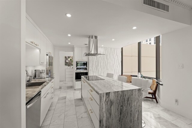5555 Del Monte Dr Unit T24, Houston, TX 77056 - kitchen with exhaust hood, stainless steel appliances, light marble finish flooring, a center island, and recessed lighting