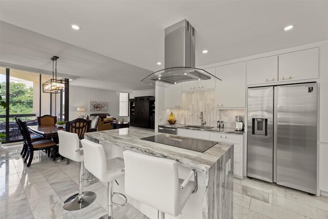 5555 Del Monte Dr Unit T24, Houston, TX 77056 - kitchen featuring appliances with stainless steel finishes, island exhaust hood, white cabinets, light marble finish floors, and recessed lighting