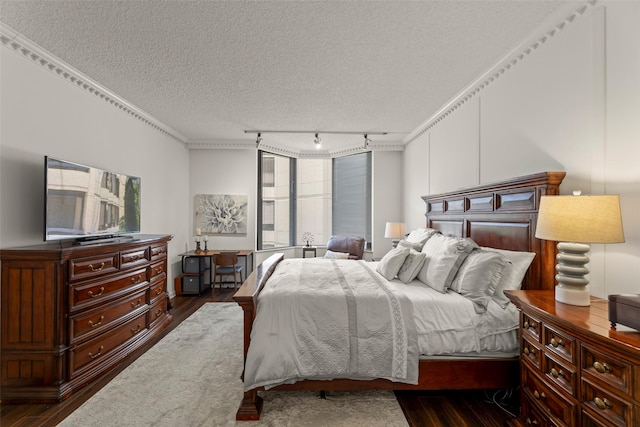 5555 Del Monte Dr Unit T24, Houston, TX 77056 - bedroom featuring dark wood finished floors, a textured ceiling, crown molding, and track lighting