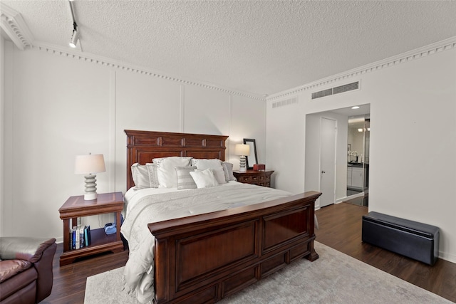 5555 Del Monte Dr Unit T24, Houston, TX 77056 - bedroom featuring a textured ceiling, wood finished floors, and rail lighting