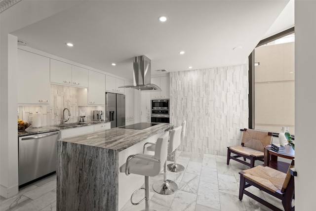 5555 Del Monte Dr Unit T24, Houston, TX 77056 - kitchen featuring stainless steel appliances, ventilation hood, light marble finish floors, a kitchen breakfast bar, and a kitchen island