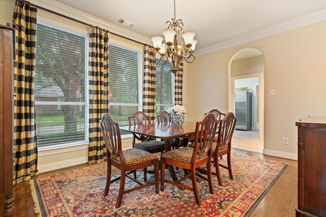 5222 Arcadia Glen Ln, Katy, TX 77494 - dining room featuring arched walkways, a chandelier, crown molding, and wood finished floors