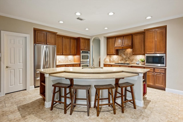 5222 Arcadia Glen Ln, Katy, TX 77494 - kitchen featuring appliances with stainless steel finishes, an island with sink, a breakfast bar, backsplash, and recessed lighting