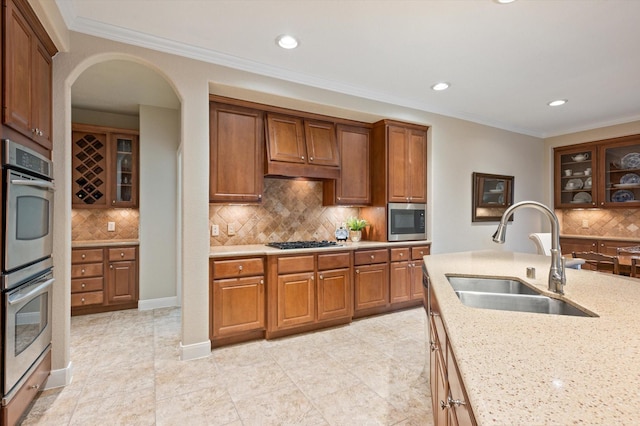 5222 Arcadia Glen Ln, Katy, TX 77494 - kitchen with appliances with stainless steel finishes, tasteful backsplash, arched walkways, glass insert cabinets, and recessed lighting