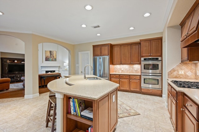 5222 Arcadia Glen Ln, Katy, TX 77494 - kitchen with appliances with stainless steel finishes, arched walkways, light stone countertops, a fireplace, and decorative backsplash