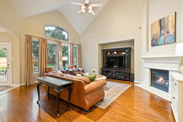 5222 Arcadia Glen Ln, Katy, TX 77494 - living area with wood-type flooring, a glass covered fireplace, arched walkways, ceiling fan, and high vaulted ceiling