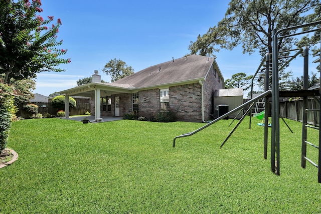 31322 Capella Cir, Tomball, TX 77375 - rear view of house with a playground, brick siding, a fenced backyard, a patio area, and a chimney