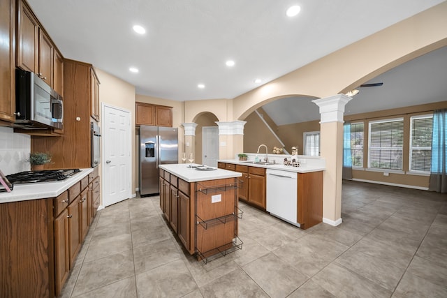 31322 Capella Cir, Tomball, TX 77375 - kitchen with stainless steel appliances, ornate columns, recessed lighting, light countertops, and brown cabinetry