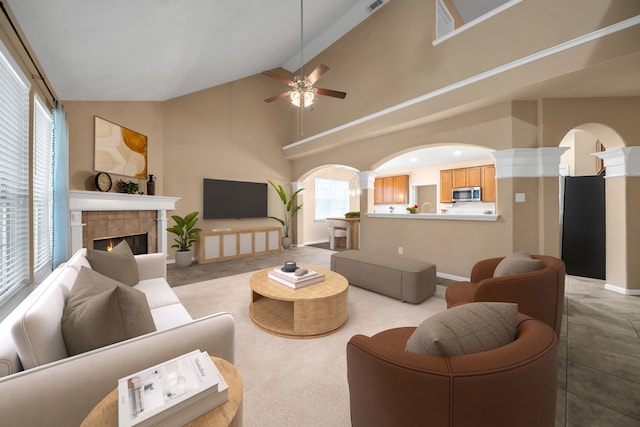 31322 Capella Cir, Tomball, TX 77375 - living room featuring high vaulted ceiling, a ceiling fan, arched walkways, ornate columns, and a fireplace