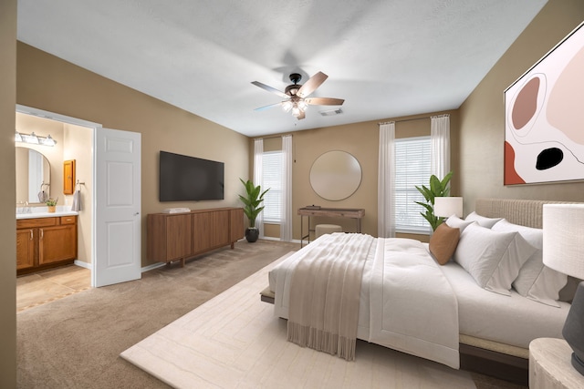 31322 Capella Cir, Tomball, TX 77375 - bedroom featuring light carpet, multiple windows, connected bathroom, and ceiling fan