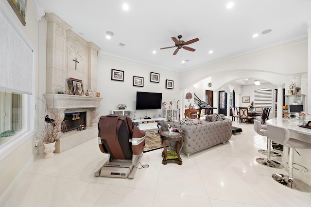 9761 Westview Dr, Houston, TX 77055 - tiled living room featuring ornate columns, arched walkways, ornamental molding, a ceiling fan, and a tiled fireplace