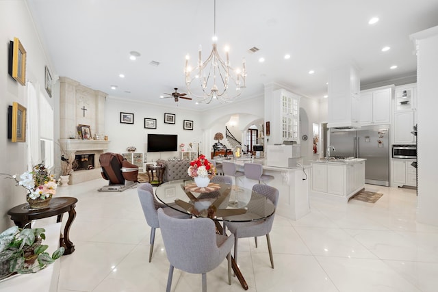 9761 Westview Dr, Houston, TX 77055 - dining space with crown molding, a chandelier, arched walkways, a fireplace, and light tile patterned floors