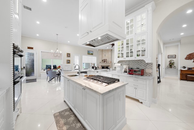 9761 Westview Dr, Houston, TX 77055 - kitchen with appliances with stainless steel finishes, white cabinetry, tasteful backsplash, arched walkways, and light stone countertops