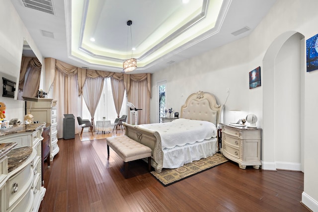 9761 Westview Dr, Houston, TX 77055 - bedroom with a tray ceiling, dark wood-style flooring, and arched walkways