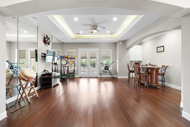 9761 Westview Dr, Houston, TX 77055 - exercise area featuring a tray ceiling, a ceiling fan, arched walkways, dark wood-style floors, and recessed lighting