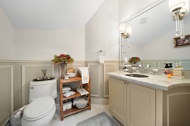 9761 Westview Dr, Houston, TX 77055 - bathroom with lofted ceiling, vanity, a wainscoted wall, a decorative wall, and tile patterned flooring