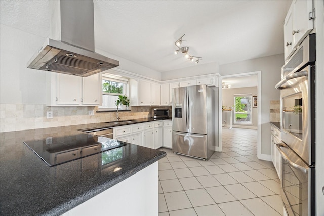 2902 Triway Ln, Houston, TX 77043 - kitchen featuring appliances with stainless steel finishes, wall chimney exhaust hood, healthy amount of natural light, and decorative backsplash