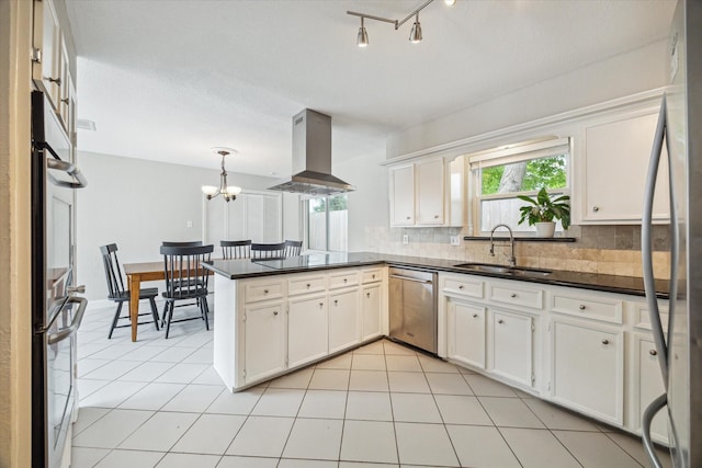 2902 Triway Ln, Houston, TX 77043 - kitchen featuring appliances with stainless steel finishes, island exhaust hood, a peninsula, dark countertops, and decorative backsplash