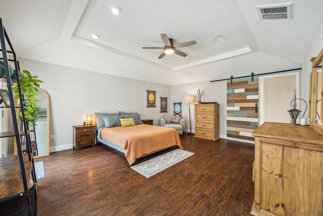 2902 Triway Ln, Houston, TX 77043 - bedroom featuring a raised ceiling, a barn door, wood finished floors, a textured ceiling, and a ceiling fan