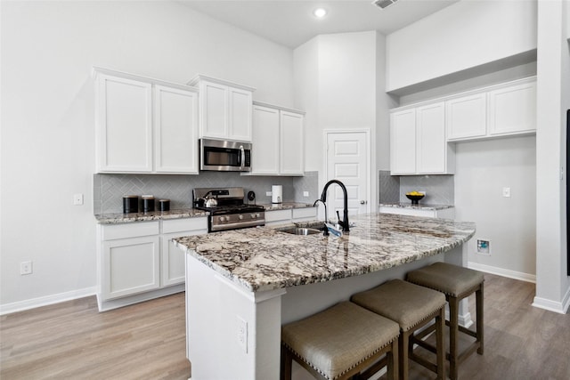 1528 Rd 66112, Dayton, TX 77535 - kitchen featuring appliances with stainless steel finishes, white cabinets, light wood finished floors, recessed lighting, and a towering ceiling
