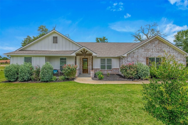 9868 Albert Dr, Iola, TX 77861 - view of front of property with a front yard, a shingled roof, brick siding, and board and batten siding