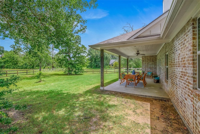 9868 Albert Dr, Iola, TX 77861 - fenced backyard featuring ceiling fan and a patio