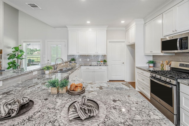 9868 Albert Dr, Iola, TX 77861 - kitchen with stainless steel appliances, decorative backsplash, white cabinetry, and recessed lighting