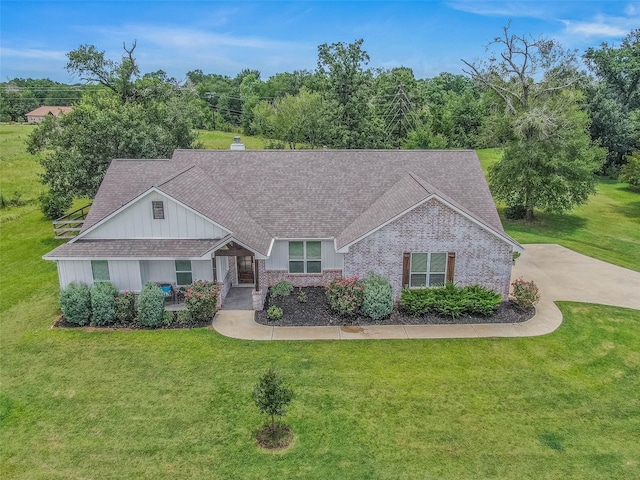 9868 Albert Dr, Iola, TX 77861 - view of front of property featuring a front lawn, a chimney, roof with shingles, and brick siding