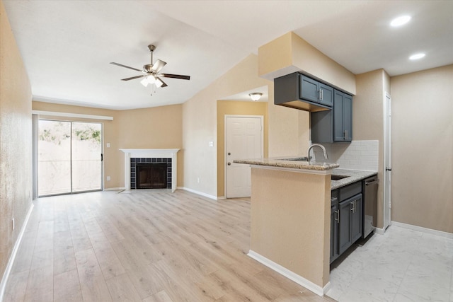 11201 Lynbrook Dr Unit 3805, Houston, TX 77042 - kitchen featuring ceiling fan, light stone counters, a tile fireplace, decorative backsplash, and dishwasher