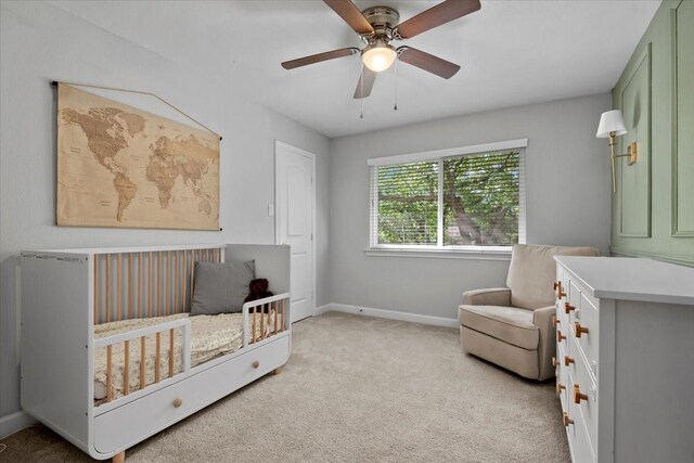 16107 Alta Mesa Dr, Houston, TX 77083 - bedroom with light colored carpet, a crib, and a ceiling fan