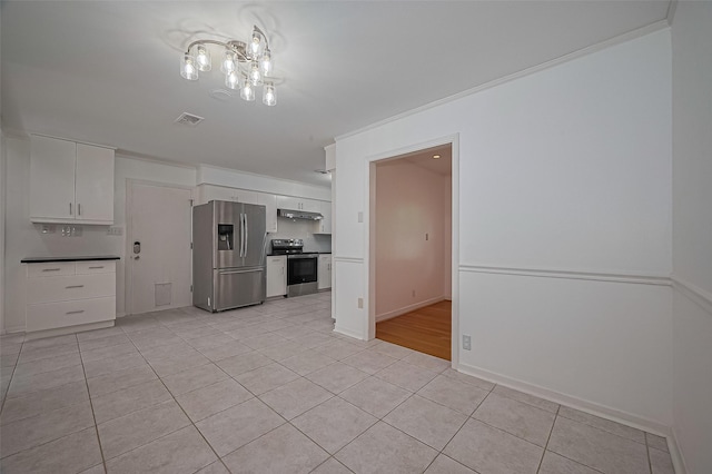 5049 De Milo Dr, Houston, TX 77092 - kitchen featuring appliances with stainless steel finishes, white cabinetry, light tile patterned floors, ornamental molding, and under cabinet range hood
