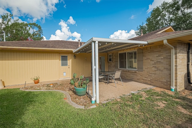 5049 De Milo Dr, Houston, TX 77092 - back of property featuring a patio area, a lawn, roof with shingles, and brick siding