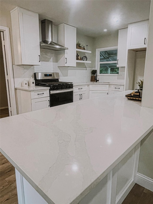4521 Kingsbury St, Houston, TX 77021 - kitchen featuring wall chimney range hood, stainless steel gas stove, white cabinets, dark wood-type flooring, and recessed lighting
