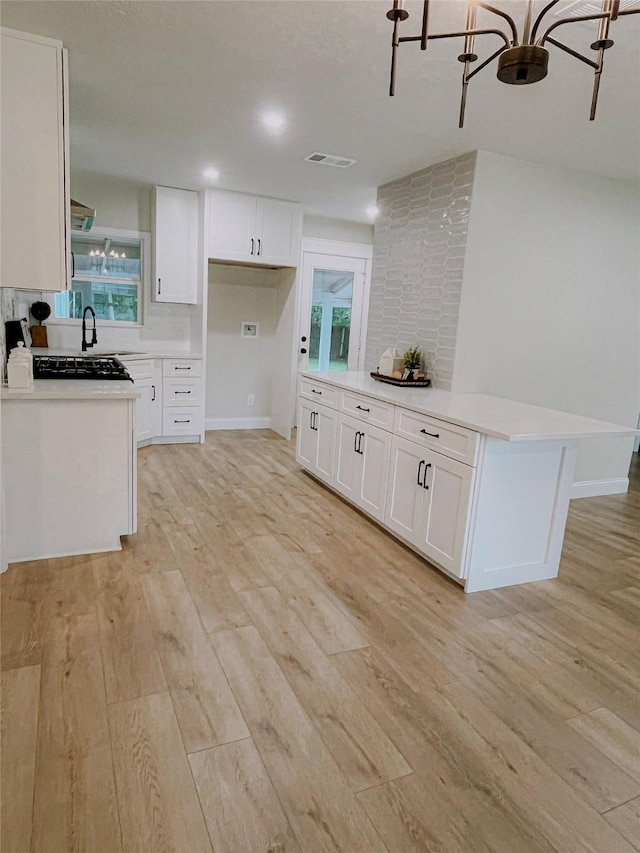 4521 Kingsbury St, Houston, TX 77021 - kitchen featuring light wood-style flooring, light countertops, and white cabinets