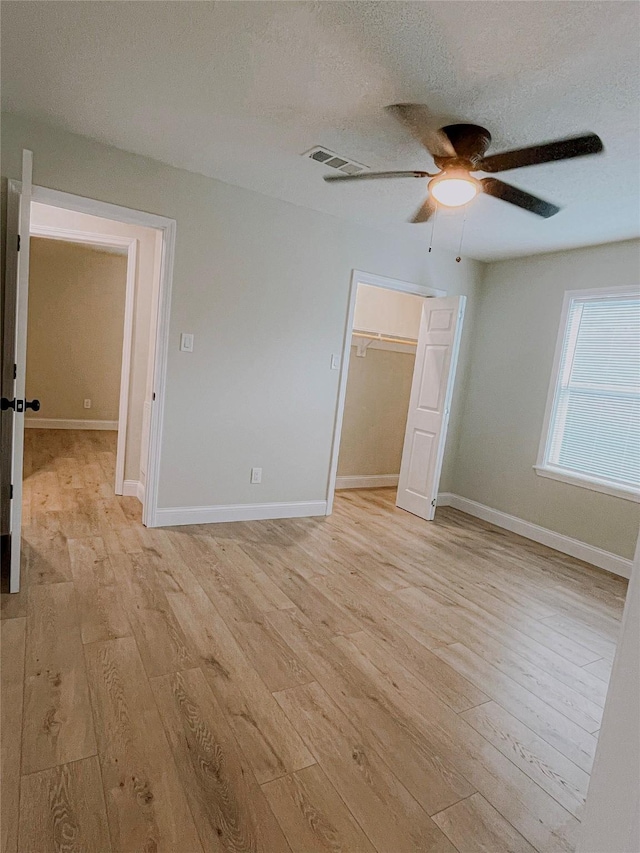 4521 Kingsbury St, Houston, TX 77021 - unfurnished bedroom featuring light wood-style floors, a ceiling fan, a textured ceiling, and a closet