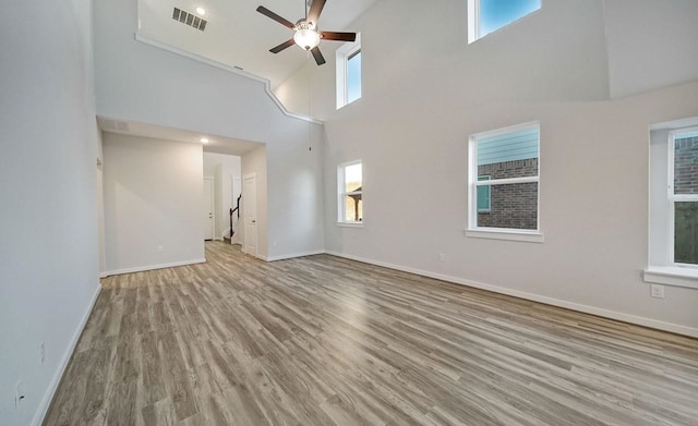 4446 Azalea Blossom Rd, Pinehurst, TX 77362 - unfurnished living room with a high ceiling, ceiling fan, wood finished floors, and plenty of natural light