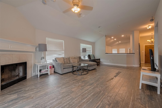 10527 Friars Hl, Houston, TX 77070 - living room featuring vaulted ceiling, wood finished floors, a ceiling fan, a tile fireplace, and a chandelier