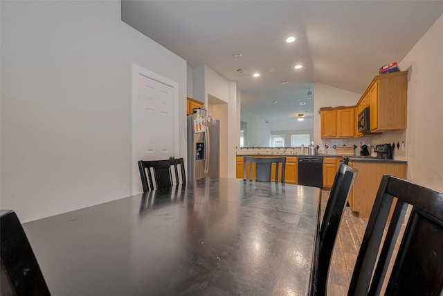 10527 Friars Hl, Houston, TX 77070 - kitchen featuring black appliances, vaulted ceiling, tasteful backsplash, a peninsula, and recessed lighting