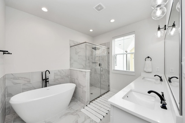 5502 Wheatley St Unit B, Houston, TX 77091 - bathroom with double vanity, a freestanding tub, marble finish floors, a stall shower, and recessed lighting