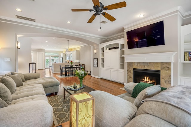 1013 Crocker St, Houston, TX 77019 - living area with arched walkways, wood finished floors, a ceiling fan, ornamental molding, and a fireplace