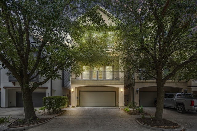 1013 Crocker St, Houston, TX 77019 - view of front of home featuring a balcony, decorative driveway, a garage, and stucco siding