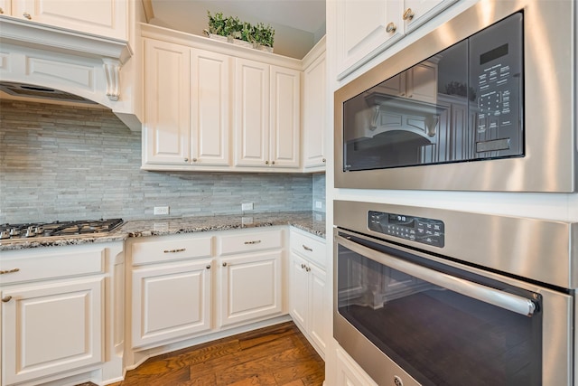 14062 Dunsmore Landing Dr, Houston, TX 77059 - kitchen with appliances with stainless steel finishes, decorative backsplash, ventilation hood, white cabinets, and light stone counters